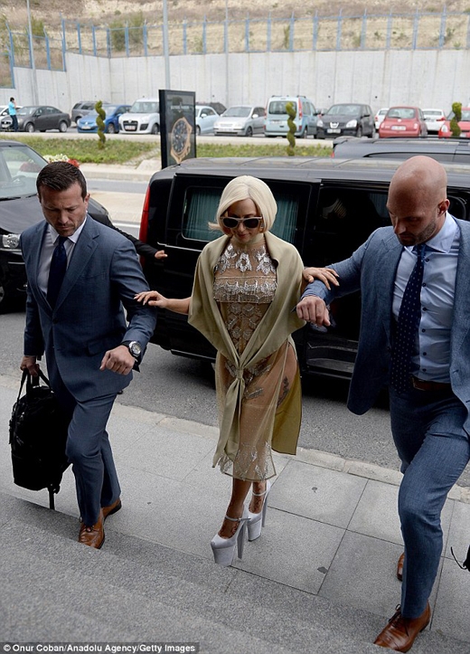 
	
	Phải nhờ đến sự trợ giúp của hai người đàn ông bên cạnh, Gaga mới có thể di chuyển vững vàng.